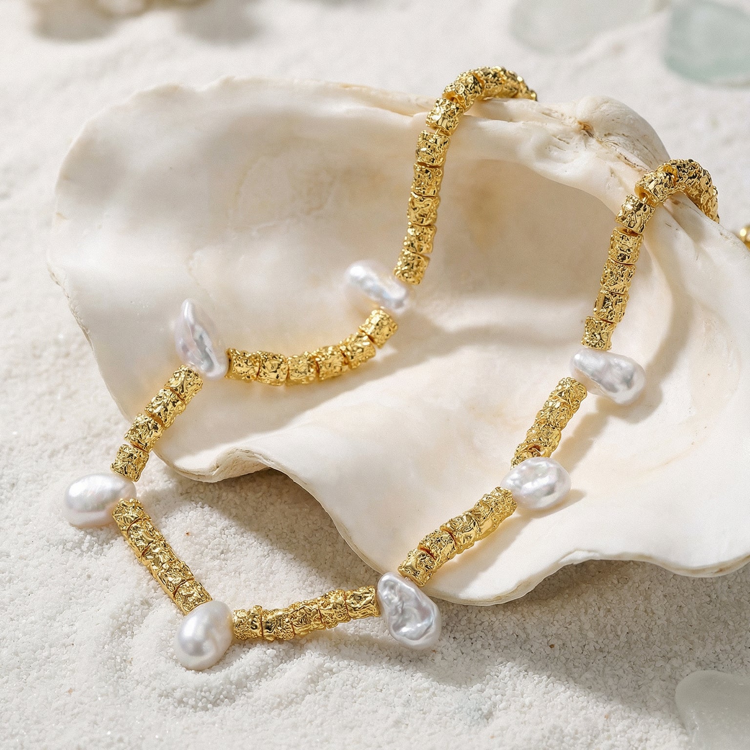 Helena George. Gold bracelet with pearls on a white shell